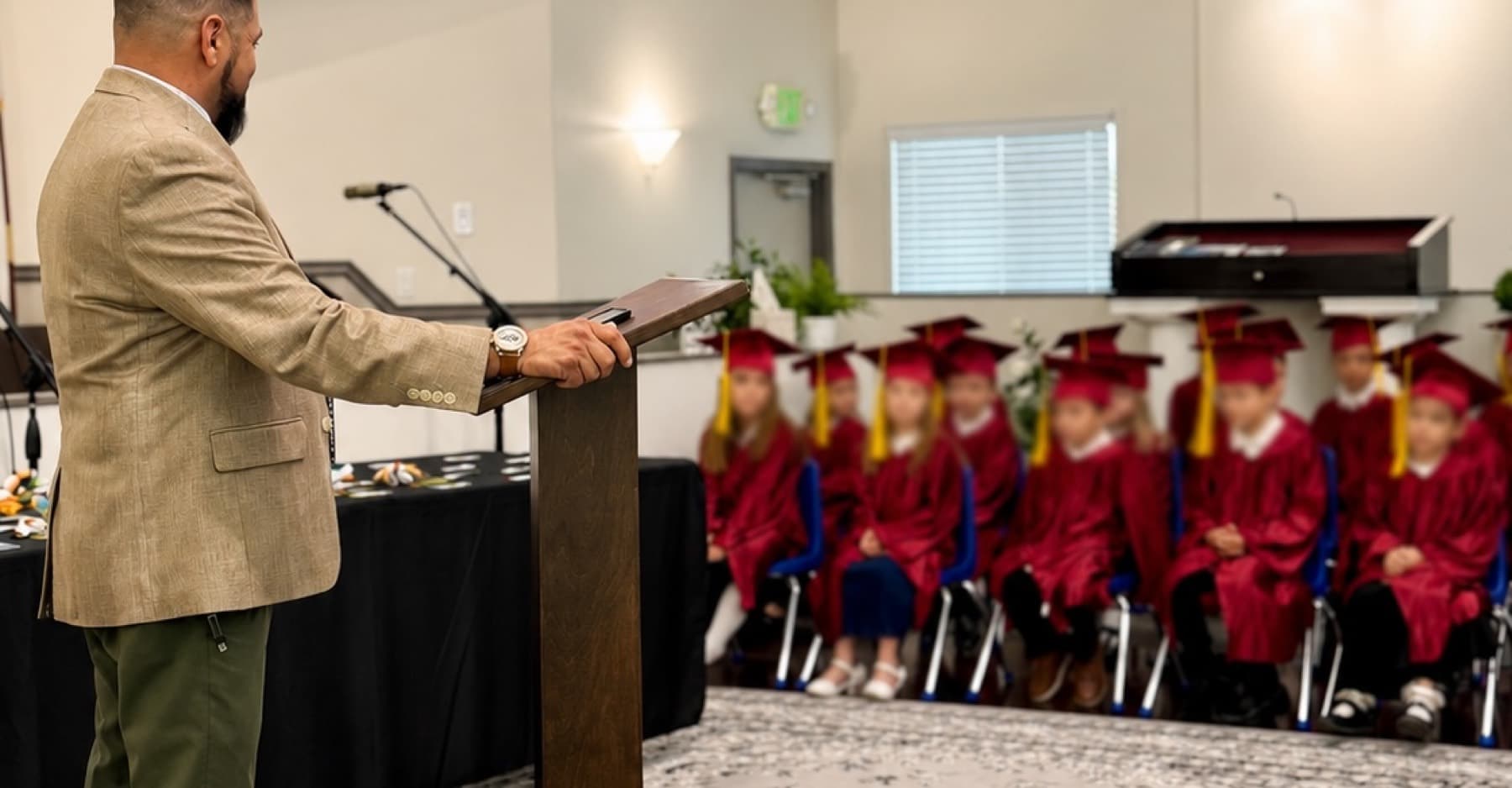Elmwood kindergarten graduates in crimson caps and gowns